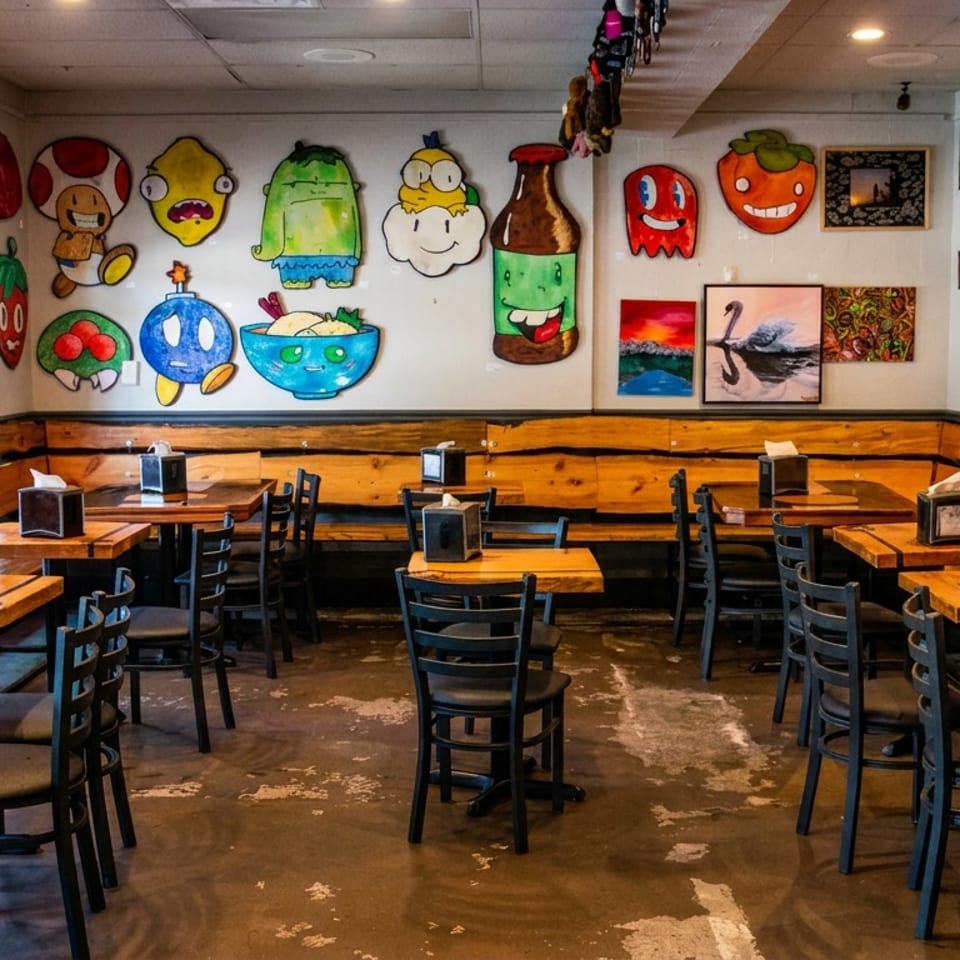 Restaurant interior with wooden tables, black chairs, and walls adorned with colorful, whimsical cartoon art.