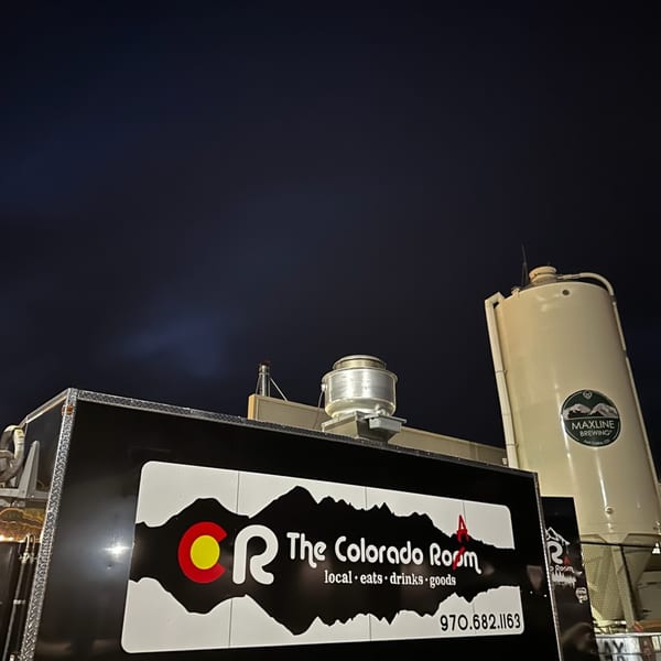 The Colorado Room food truck parked at night with a Maxline Brewing silo in the background.