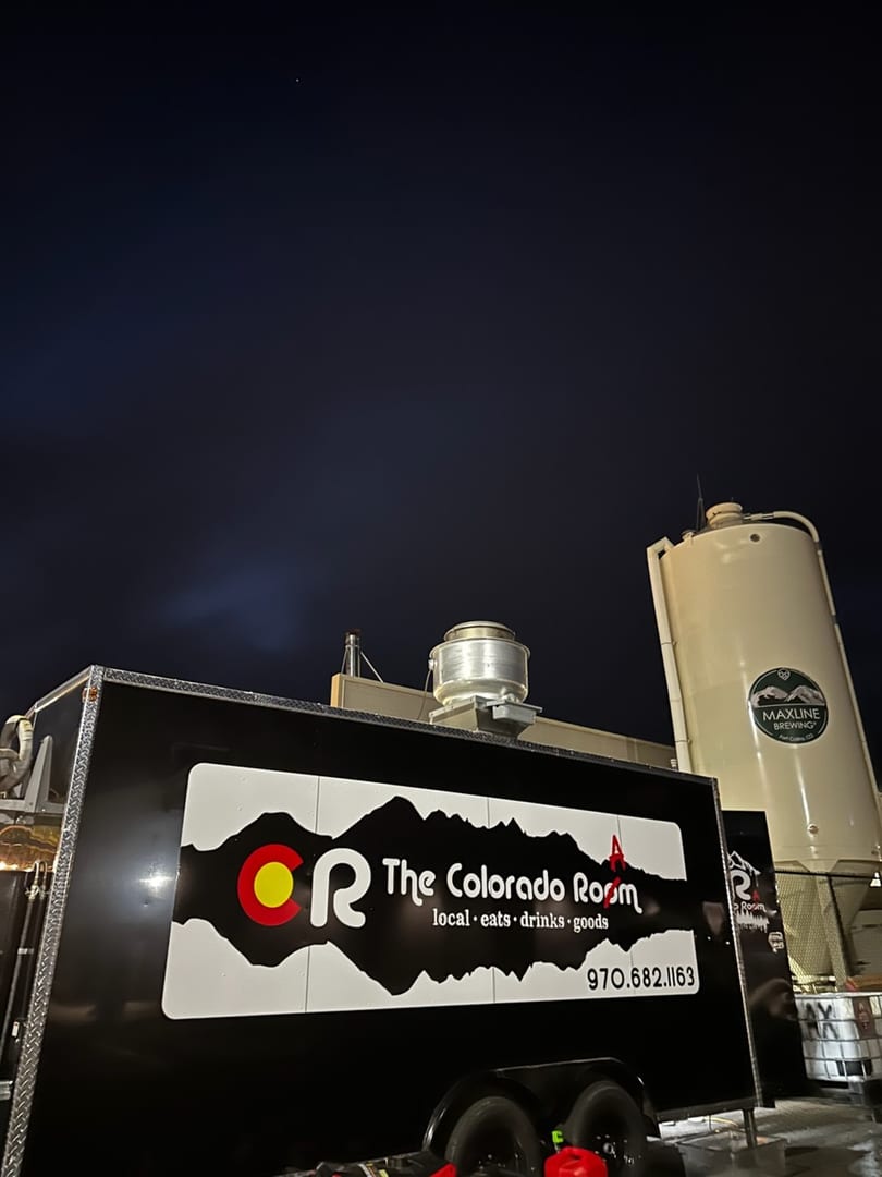 The Colorado Room food truck parked at night with a Maxline Brewing silo in the background.